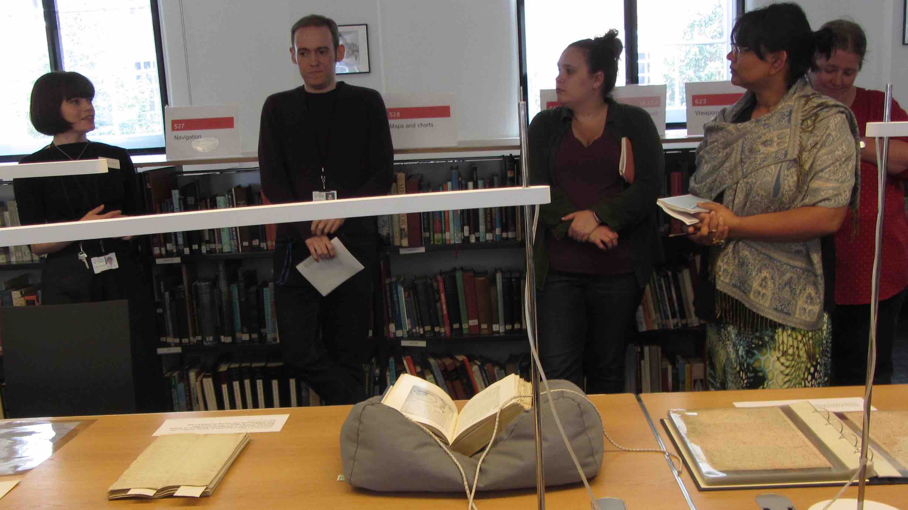 Students gathered around objects listening to archivists discussing their history